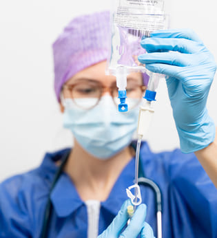 Врач держит капельницу